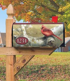 a mailbox with a cardinal painted on it's front and the number thirteen