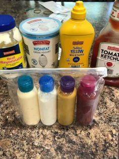 the ingredients for an ice cream dessert are in plastic containers on the counter top, along with milk and yogurt