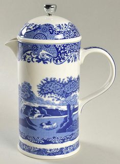 a blue and white coffee pot with a tree on the side, in front of a white background