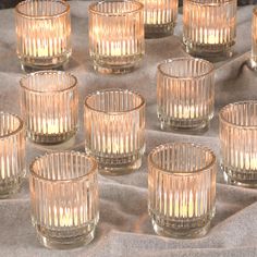 many clear glass cups sitting on top of a table