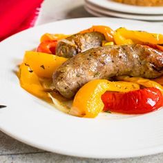 sausage and peppers are on a white plate