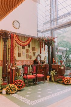 the room is decorated with orange and red flowers, greenery, and an ornate clock on the wall