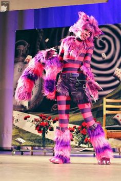 a woman in pink and black costume standing on stage