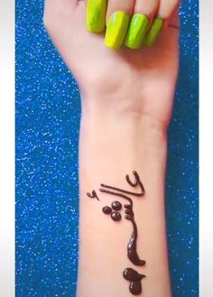 a woman's wrist with green and black designs on it