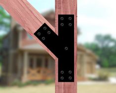 a close up of a wooden post with a house in the backgroung