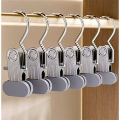 a set of five metal clothes hangers on a rail in front of a door