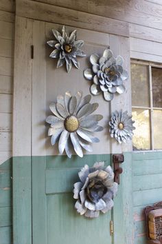 three metal flowers mounted to the side of a door