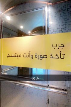 a yellow sign hanging from the side of a glass wall in front of a door