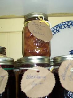 several jars with labels on them are sitting on a shelf