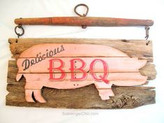 a wooden sign that says delicious bbq hangs on a white wall next to a pipe