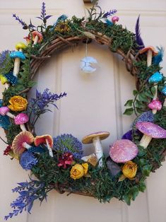 a wreath with flowers and mushrooms on it