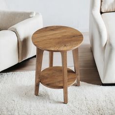 a small wooden table sitting on top of a white rug next to a couch and chair