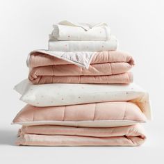 a stack of pillows and blankets sitting next to each other on top of each other