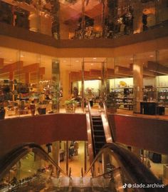 an escalator in a large building with lots of glass and metal railings