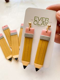 a pair of yellow pencils with pink and grey erasers attached to them are being held by a hand