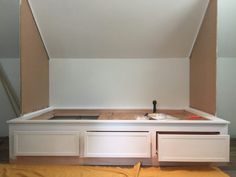 an unfinished room with white cabinets and yellow sheets