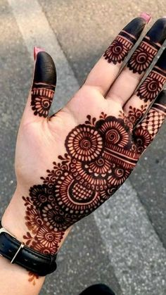 a woman's hand with henna tattoos on it