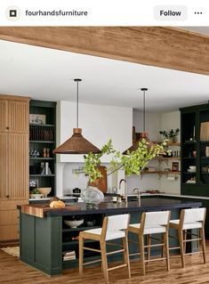 an open kitchen with green cabinets and white counter tops, along with wooden flooring