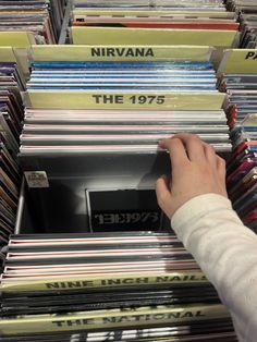 a person picking up records from a record store