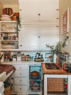 a kitchen with white cabinets and wooden counter tops