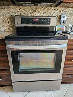 a stainless steel stove and microwave in a kitchen with granite counter tops, drawers, and cabinets