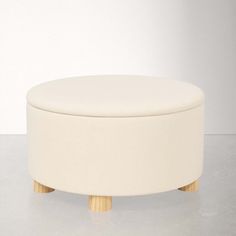 a white ottoman sitting on top of a cement floor