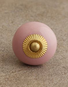 a close up of a pink ball with gold decoration on the front and back end