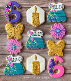 decorated cookies are arranged in the shape of flowers, candles and other things on a wooden surface