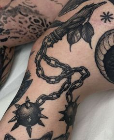 a man's arm with tattoos on it and chains attached to the arm,