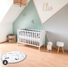 a baby's room with a white crib and blue walls, wooden flooring