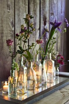 vases filled with flowers and candles sitting on a table