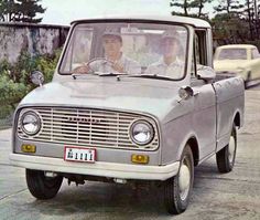 two men are driving in an old truck