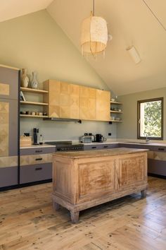 a kitchen with wooden floors and cabinets in the center, along with an island countertop