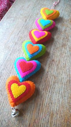 a row of heart shaped key chains sitting on top of a wooden table