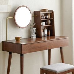 a wooden desk with a mirror, stool and shelf on it in front of a white wall