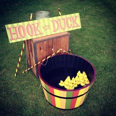 a bucket filled with rubber ducks next to a sign that says hook the duck