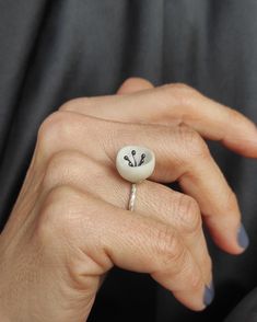 "This minimal distinctive ring is made of silver and matte white porcelain. The shape of the porcelain is round and hollow with irregular edges and the inside part is decorated with oxidized silver wires. The band has a very nice particular texture.A very simple ring for your everyday outfit. There may be a slight difference between the pieces, because they are all made by hand one by one. The porcelain is left matte, in its natural texture , without any use of enamel and glazing, highlighting its beauty and its properties. Handle with care because porcelain is somewhat brittle in such a small scale. If it falls down on a hard surface, it can be damaged. Each piece is hand shaped by me before being fired in a kiln to 1240C. DESCRIPTIONS and MEASUREMENTS: Materials:Sterling silver and oxidi Jewellery Ceramic, Ring Elegant, Ceramic Ring, Simple Ring, Ceramic Rings, Textured Ring, Minimalist Ring, Hand Shapes, Everyday Outfit