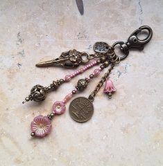 a key chain with some charms hanging from it's end on a marble surface