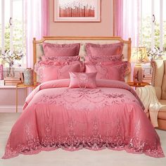 a bed with pink comforters and pillows in a room