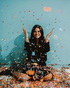 a woman sitting on the floor surrounded by confetti