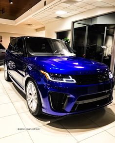 a blue range rover parked in a showroom