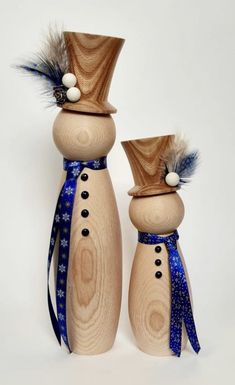 two wooden salt and pepper shakers decorated with blue ribbon, white balls and feathers