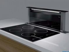 an electric stove top on a countertop in a kitchen with wood flooring and white walls