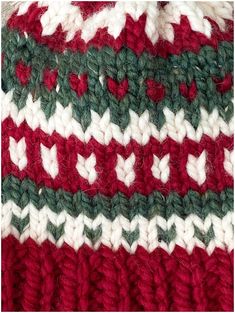 a red, white and green knitted blanket with hearts