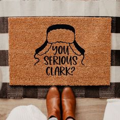 a person standing in front of a door mat that says, you serious clark?