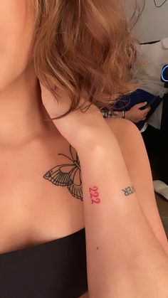 a woman with a butterfly tattoo on her left arm and right arm behind her head