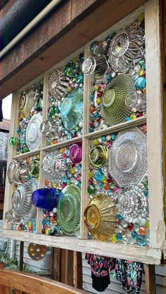 an old window is filled with glass dishes