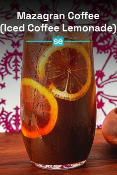 a glass filled with iced coffee and orange slices