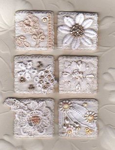 four square white tiles with flowers and pearls on the bottom one is decorated in gold, silver, and white