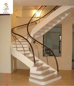 there is a spiral staircase in the middle of this room with wood floors and white railings